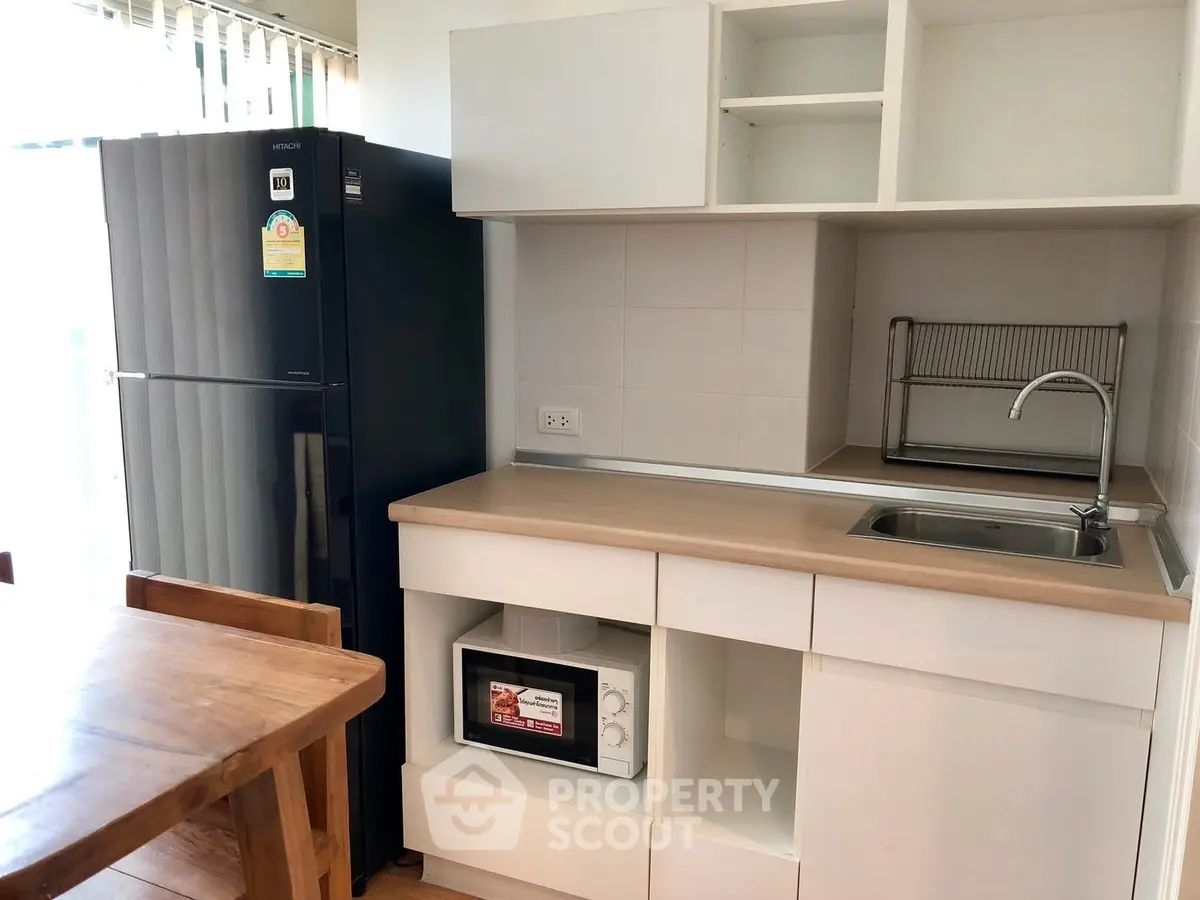 Modern kitchen with sleek black fridge and wooden dining table