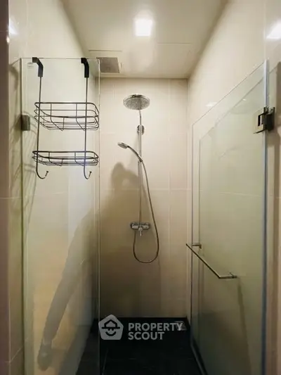 Modern bathroom with glass shower enclosure and overhead rain shower fixture.
