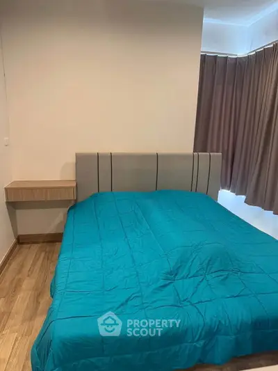 Cozy bedroom with modern design and vibrant blue bedding, perfect for relaxation.