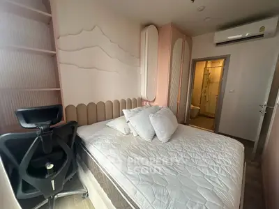 Modern bedroom with stylish decor and ergonomic chair, featuring a cozy bed and air conditioning.