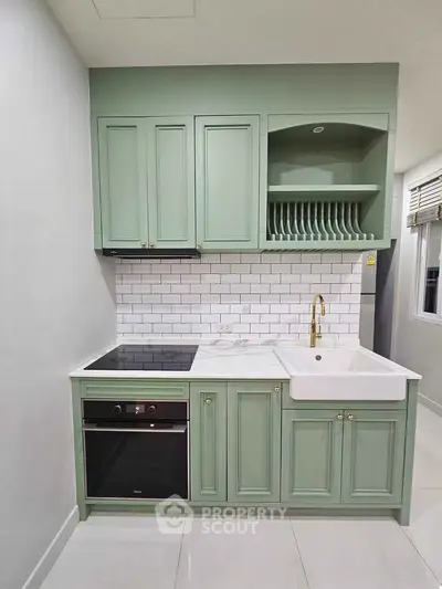 Charming kitchen with mint green cabinets and modern appliances, perfect for culinary enthusiasts.