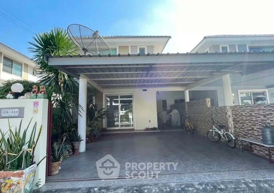 Charming suburban home with spacious carport and lush greenery, perfect for family living.