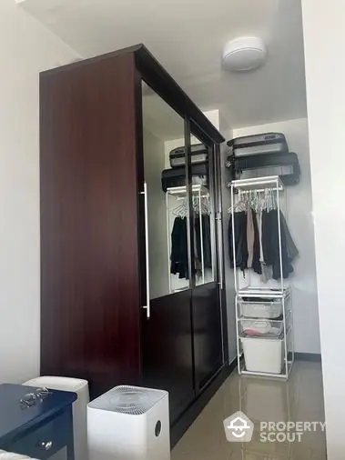 Sleek modern wardrobe in a well-organized interior space with ample storage solutions, reflecting a practical and stylish living environment.