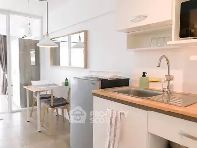 Modern kitchen with dining area, featuring sleek cabinetry and contemporary lighting in a bright, airy space.
