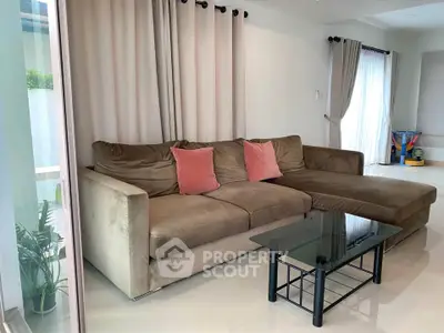 Spacious living room with plush sofa and modern decor, perfect for relaxation and entertaining.