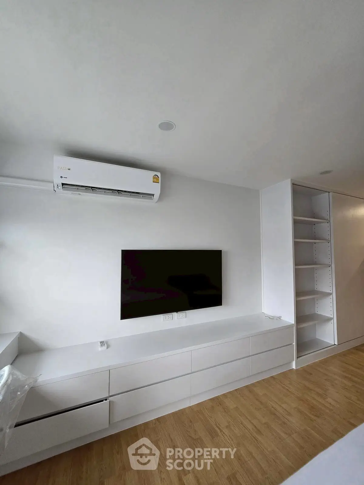 Modern minimalist living room with wall-mounted TV and air conditioner