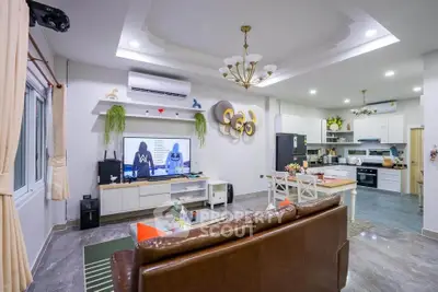 Spacious modern living room with open kitchen, stylish decor, and elegant lighting in a contemporary home.