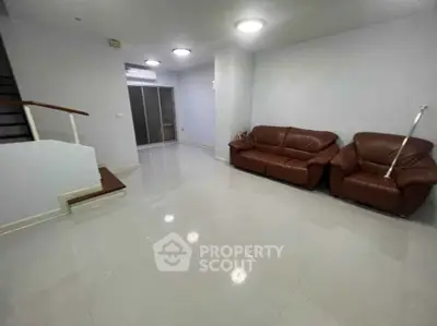 Spacious living room with modern leather sofas and sleek tile flooring