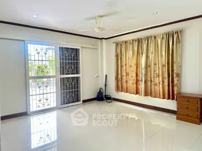 Spacious living room with glossy tiled floors and elegant curtains