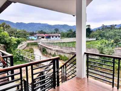 Scenic balcony view overlooking lush greenery and distant mountains, perfect for nature lovers.