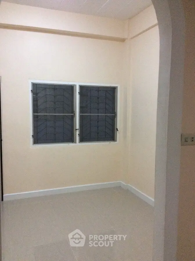 Minimalist empty room with tiled floor and two windows, perfect for customization.