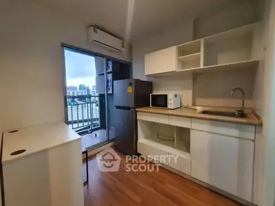 Modern kitchen with balcony view, featuring sleek cabinetry and appliances in a compact layout.
