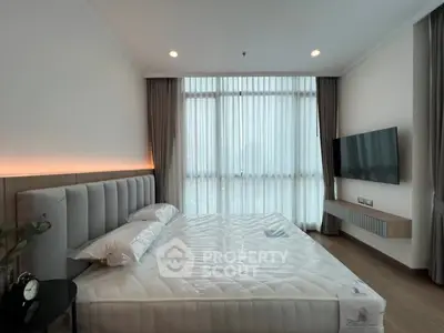 Luxurious bedroom with modern decor and large window offering natural light.