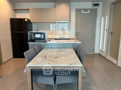 Modern kitchen with marble dining table and sleek appliances in a stylish apartment.