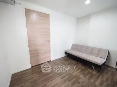 Minimalist room with wooden flooring and modern sofa, perfect for cozy living space.