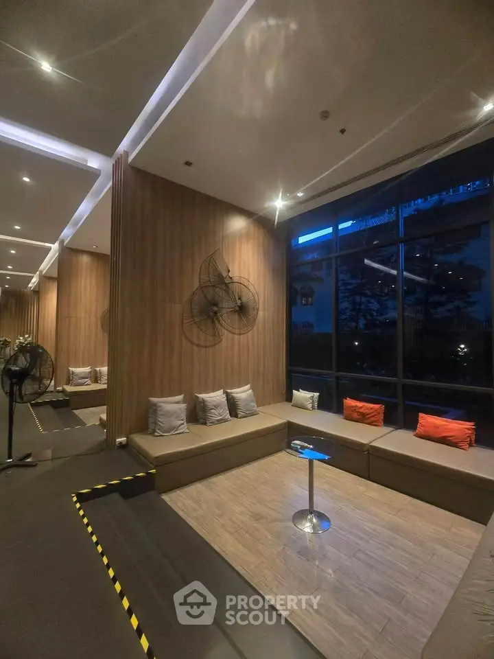 Modern lobby with stylish seating and large windows in a contemporary building.