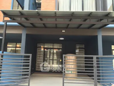 Modern building entrance with sleek design and gated access