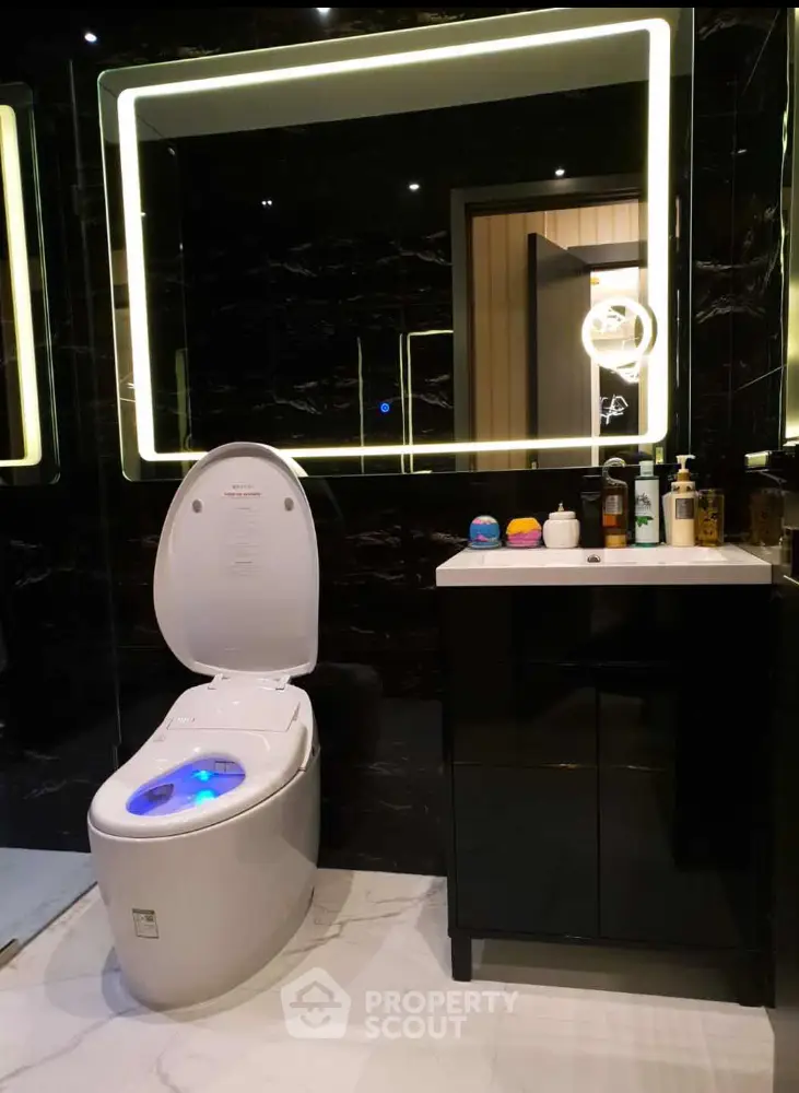 Luxurious modern bathroom with high-tech toilet and sleek vanity in elegant black and white design.