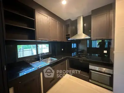 Modern kitchen with sleek dark cabinets and built-in oven