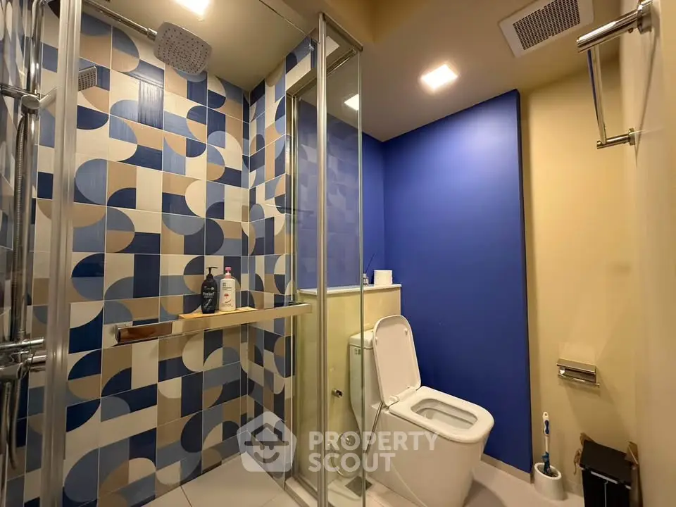 Modern bathroom with geometric tile design and glass shower enclosure