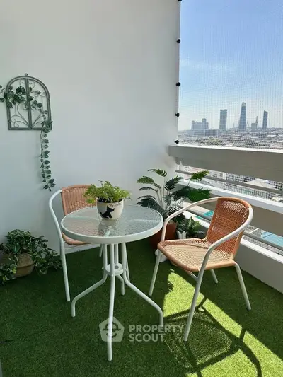 Charming balcony with city view, featuring cozy seating and lush greenery, perfect for relaxation.