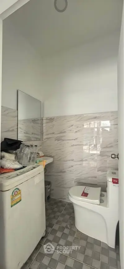 Compact bathroom with modern tiles and essential fixtures