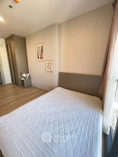 Modern bedroom with stylish decor and large window offering natural light