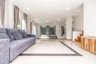 Spacious modern living room with sleek tile flooring and elegant gray sofa