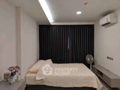 Modern bedroom with minimalist decor and air conditioning, featuring a comfortable bed and sleek furnishings.