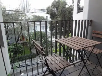 Charming balcony with wooden furniture and city view, perfect for relaxing outdoors.