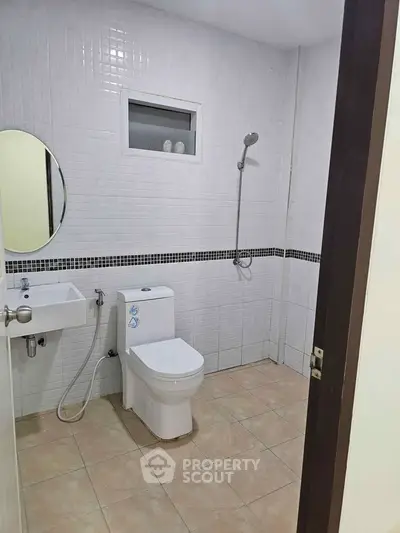 Modern bathroom with sleek fixtures and tiled walls, featuring a shower and toilet.