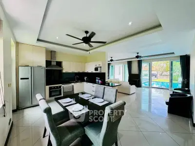 Spacious open-plan kitchen and living area with pool view, modern appliances, and elegant dining setup.