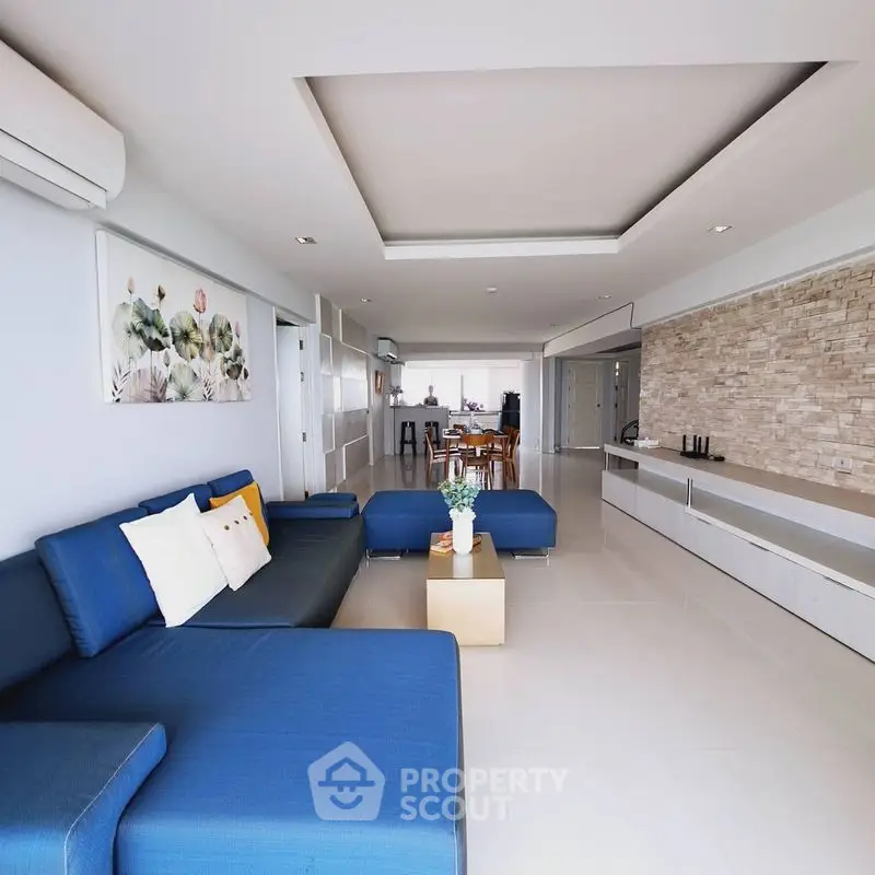 Spacious modern living room with blue sectional sofa and stylish decor