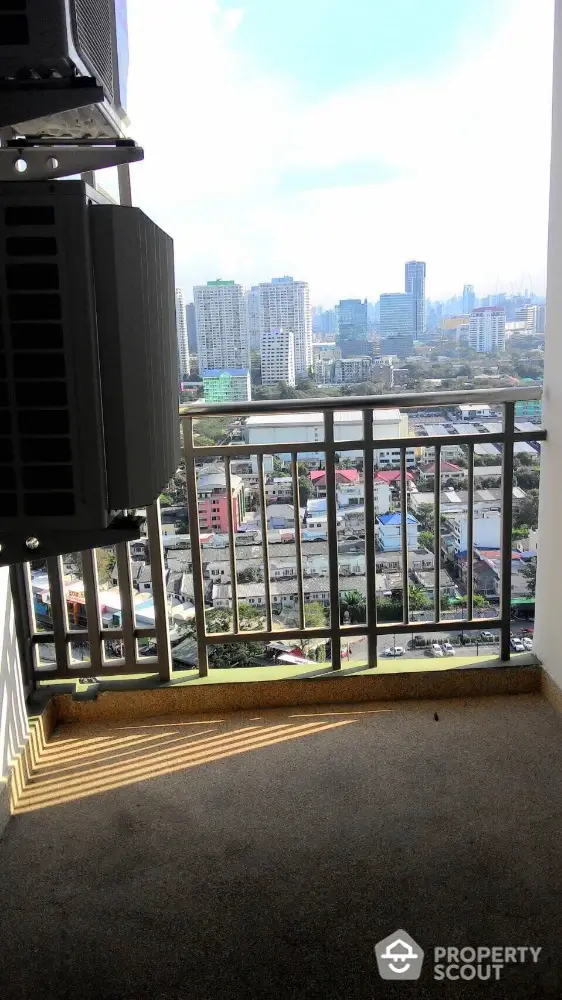 Stunning city view from a high-rise balcony with modern railing and urban skyline.