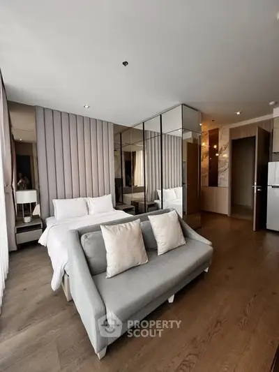 Modern bedroom with stylish decor and cozy seating area in a luxurious apartment.