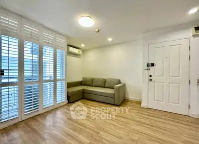 Spacious living room with wooden flooring and modern sofa in bright apartment