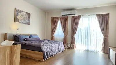 Spacious bedroom with modern decor and large window for natural light