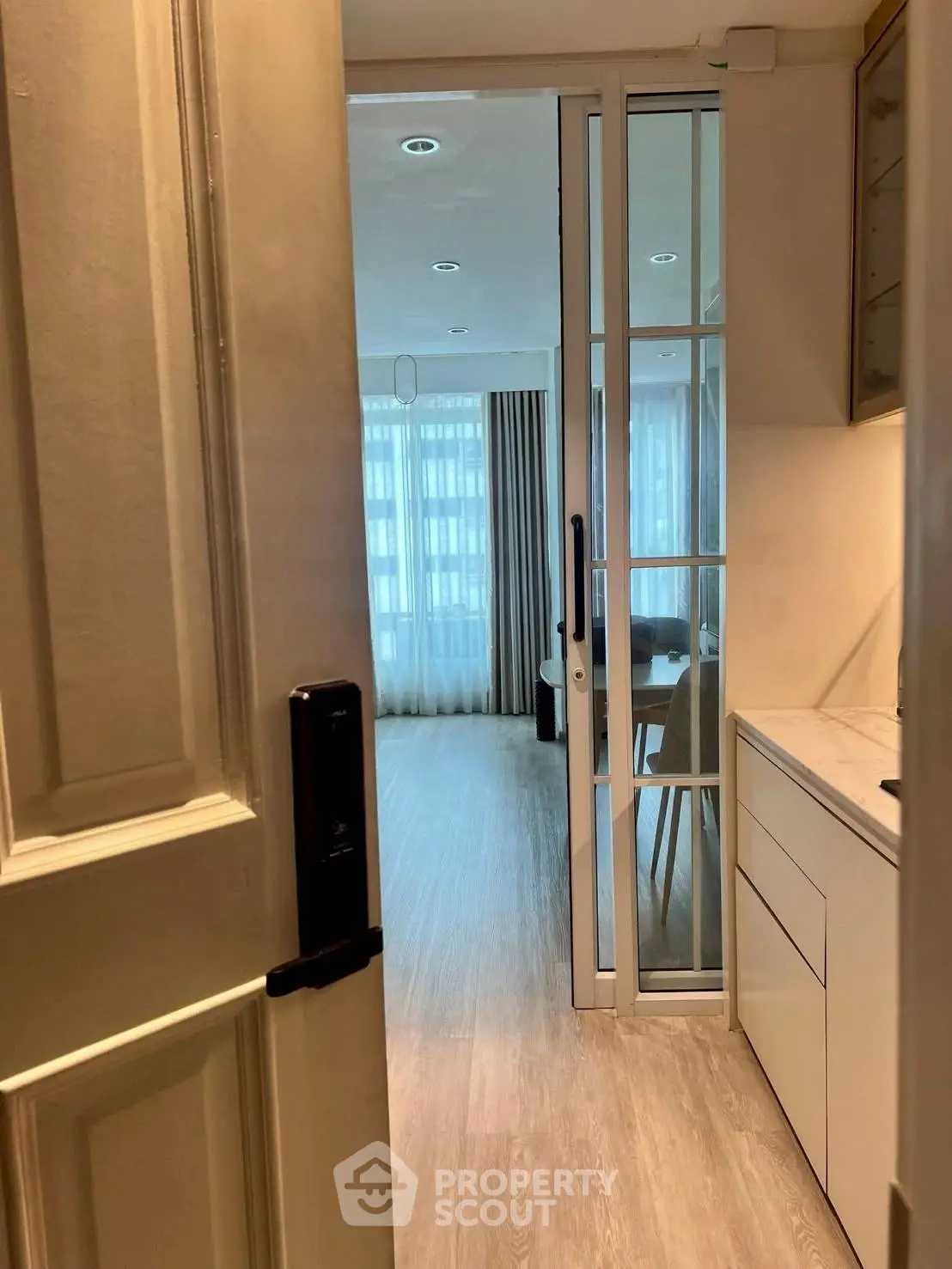 Modern apartment entrance with sliding glass door and bright interior