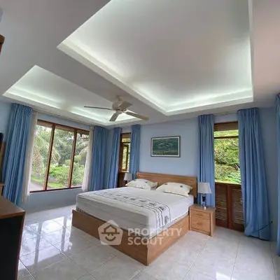 Spacious bedroom with large windows and serene garden view, featuring modern ceiling design and cozy decor.