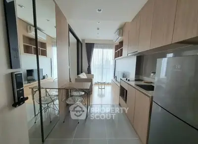 Modern open-layout kitchen with sleek appliances and cozy dining area in a stylish apartment.