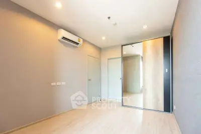 Spacious empty bedroom with mirrored closet and air conditioning