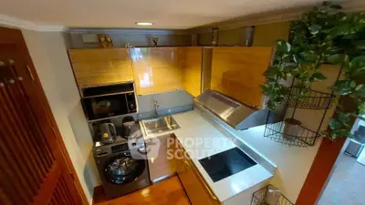 Modern kitchen with sleek cabinetry, built-in appliances, and stylish decor in a compact layout.