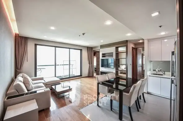 Spacious modern living room with open kitchen and large windows in a luxury apartment.