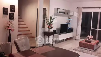 Elegant living room with modern decor and open layout, featuring stylish furniture and a cozy ambiance.