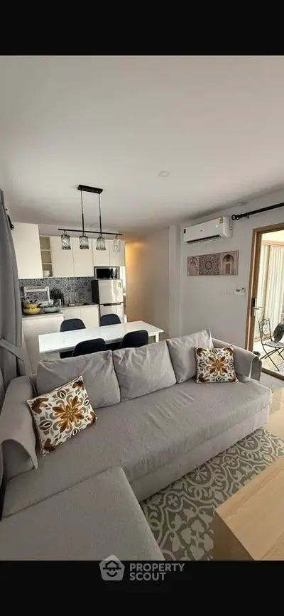 Modern open-plan living room with stylish kitchen and cozy seating area, perfect for entertaining.