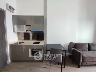 Modern compact kitchen with dining area and cozy sofa in open-plan layout