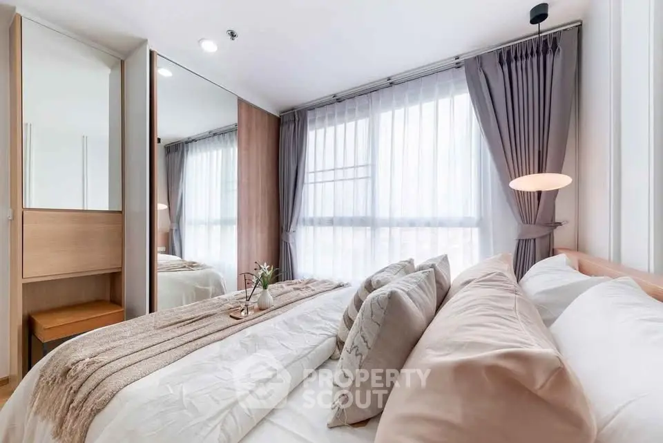 Elegant bedroom with cozy bedding and natural light, featuring modern decor and stylish curtains.