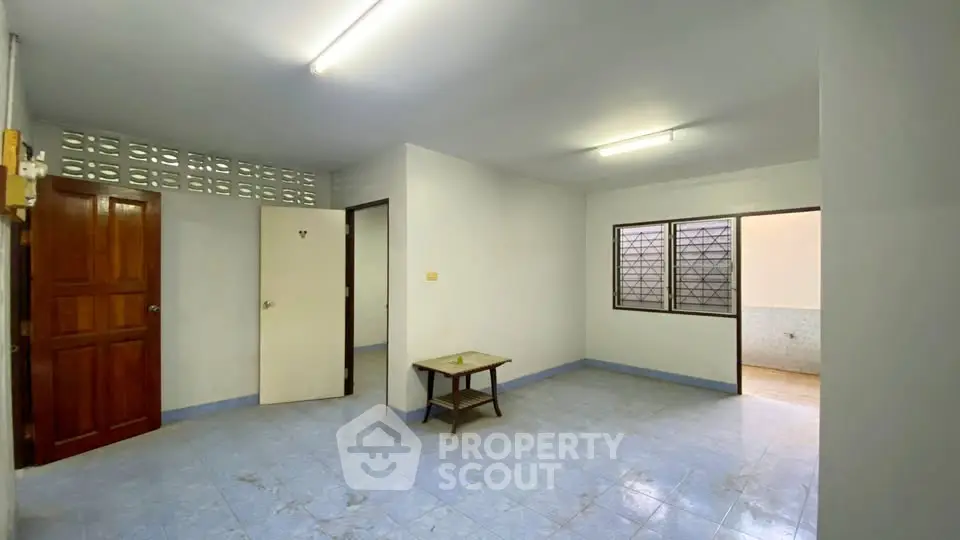 Spacious living room with tiled flooring and natural light, ideal for cozy gatherings.