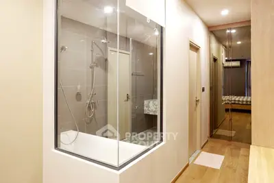 Modern apartment interior with glass-enclosed bathroom and wooden flooring