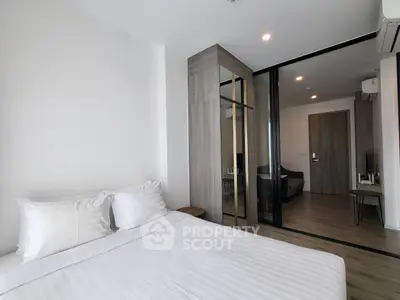 Modern bedroom with mirrored wardrobe and sleek wooden flooring
